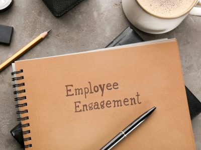 Notepad with text EMPLOYEE ENGAGEMENT on table
